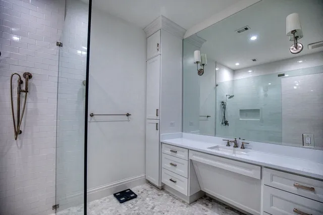 a bathroom with a double vanity sink a mirror and a shower