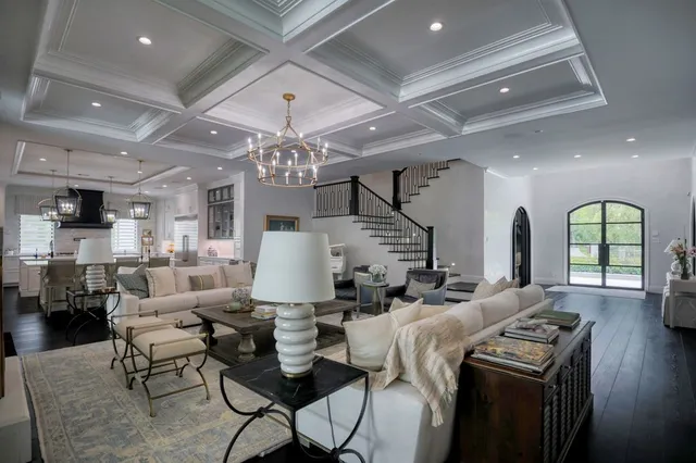 a living room with furniture a chandelier and a dining table