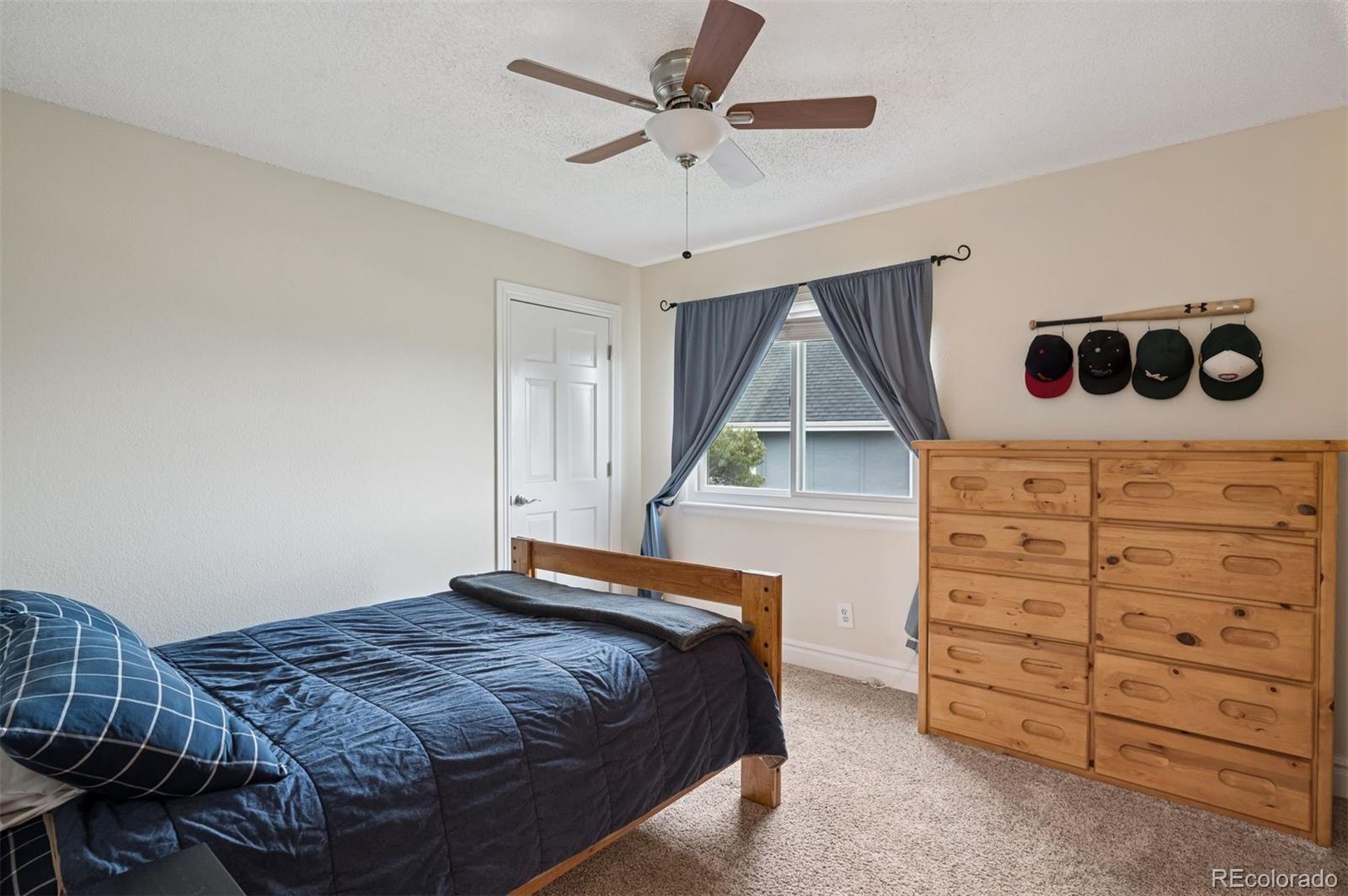 2187 Wynterbrook Drive Highlands Ranch, CO 80126 - Photo 25 of 41 a bedroom with a bed and a chandelier