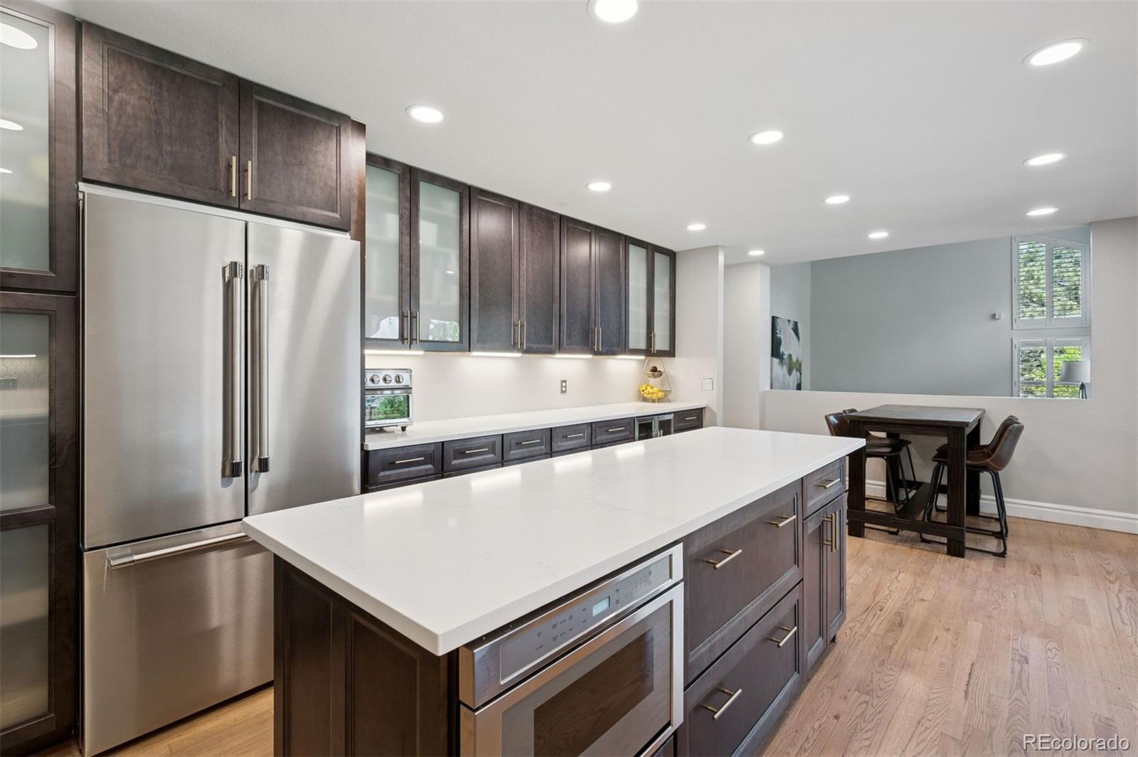 2187 Wynterbrook Drive Highlands Ranch, CO 80126 - Photo 7 of 41 a kitchen with a refrigerator a table and chairs