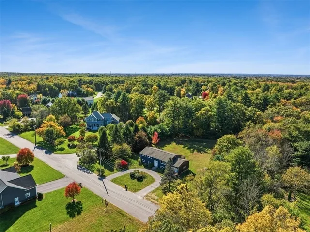 an aerial view of residential house with outdoor space and trees all around