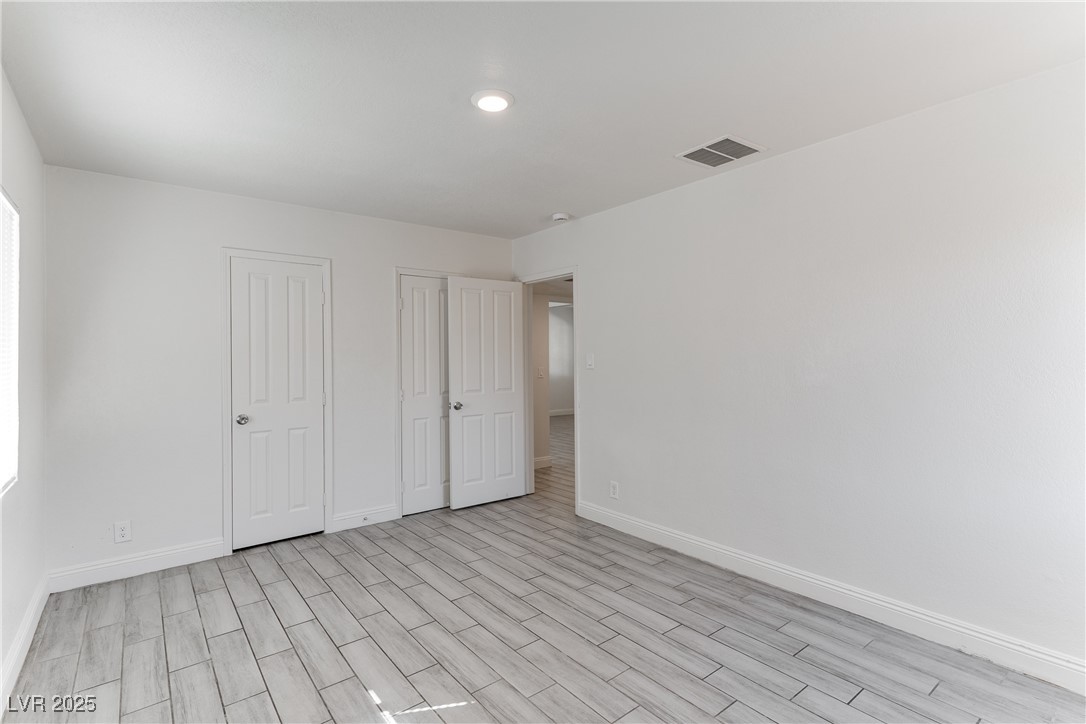 309 North 16th Street, Unit A Las Vegas, NV 89101 - Photo 12 of 23 Unfurnished bedroom featuring multiple closets, wood finish floors, and recessed lighting