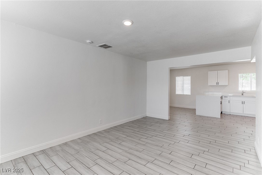 309 North 16th Street, Unit A Las Vegas, NV 89101 - Photo 14 of 23 Unfurnished living room featuring plenty of natural light and wood tiled floors