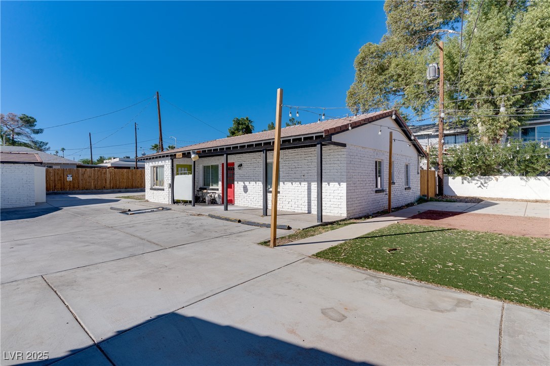 309 North 16th Street, Unit A Las Vegas, NV 89101 - Photo 4 of 23 Rear view of house featuring brick siding and a fenced backyard