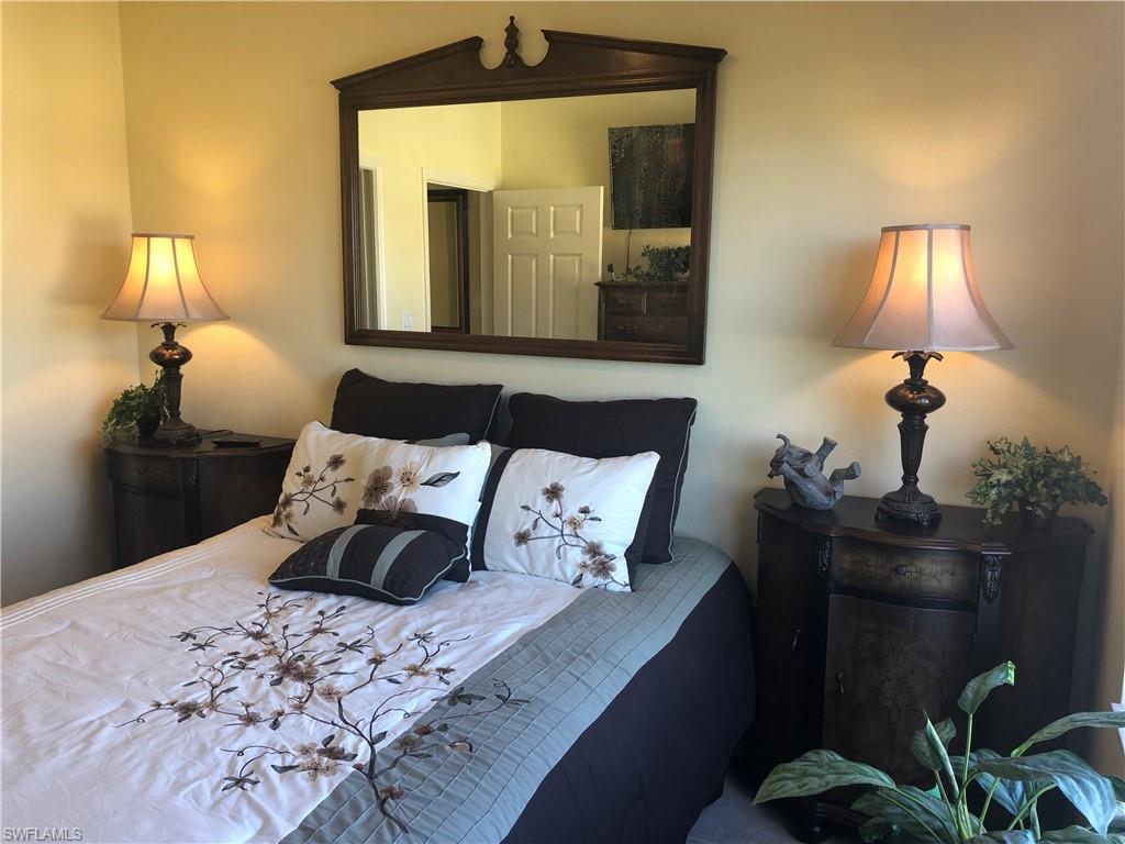 451 Bayfront Place, Unit 5311 Naples, FL 34102 - Photo 31 of 38 a bedroom with a bed and a lamp on dresser