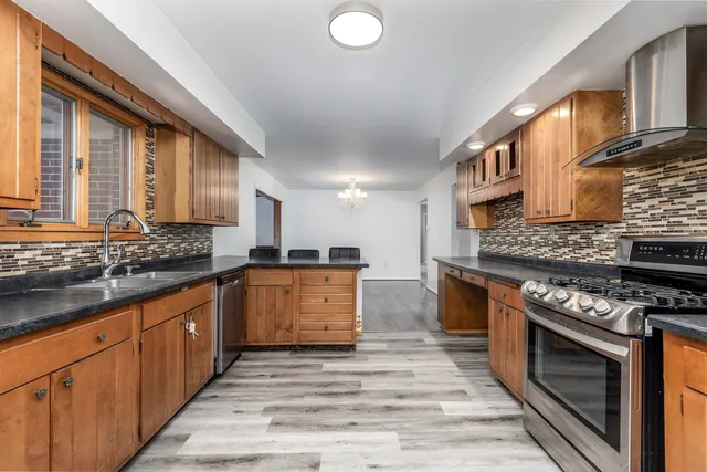 a kitchen with stainless steel appliances granite countertop a stove a sink and a refrigerator