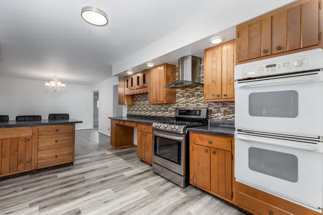 a kitchen with granite countertop a table chairs microwave and cabinets