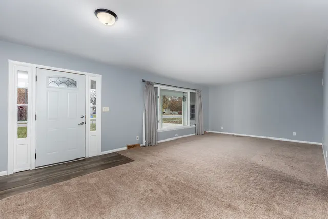 a view of empty room with kitchen