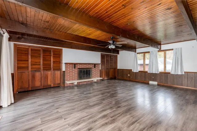 a view of empty room with wooden floor and fireplace