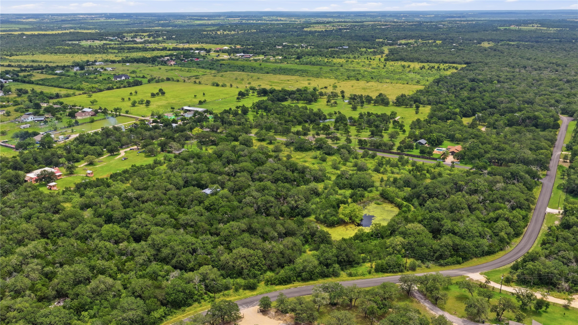 10312 Parsons Road Manor, TX 78653 - Photo 5 of 26 Scenic aerial views showcase expansive green landscapes, mature trees, and winding roads.