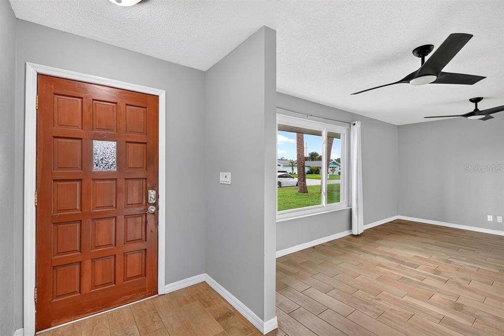 1309 Suwanee Road Daytona Beach, FL 32114 - Photo 4 of 33 a view of an empty room with wooden floor and a window