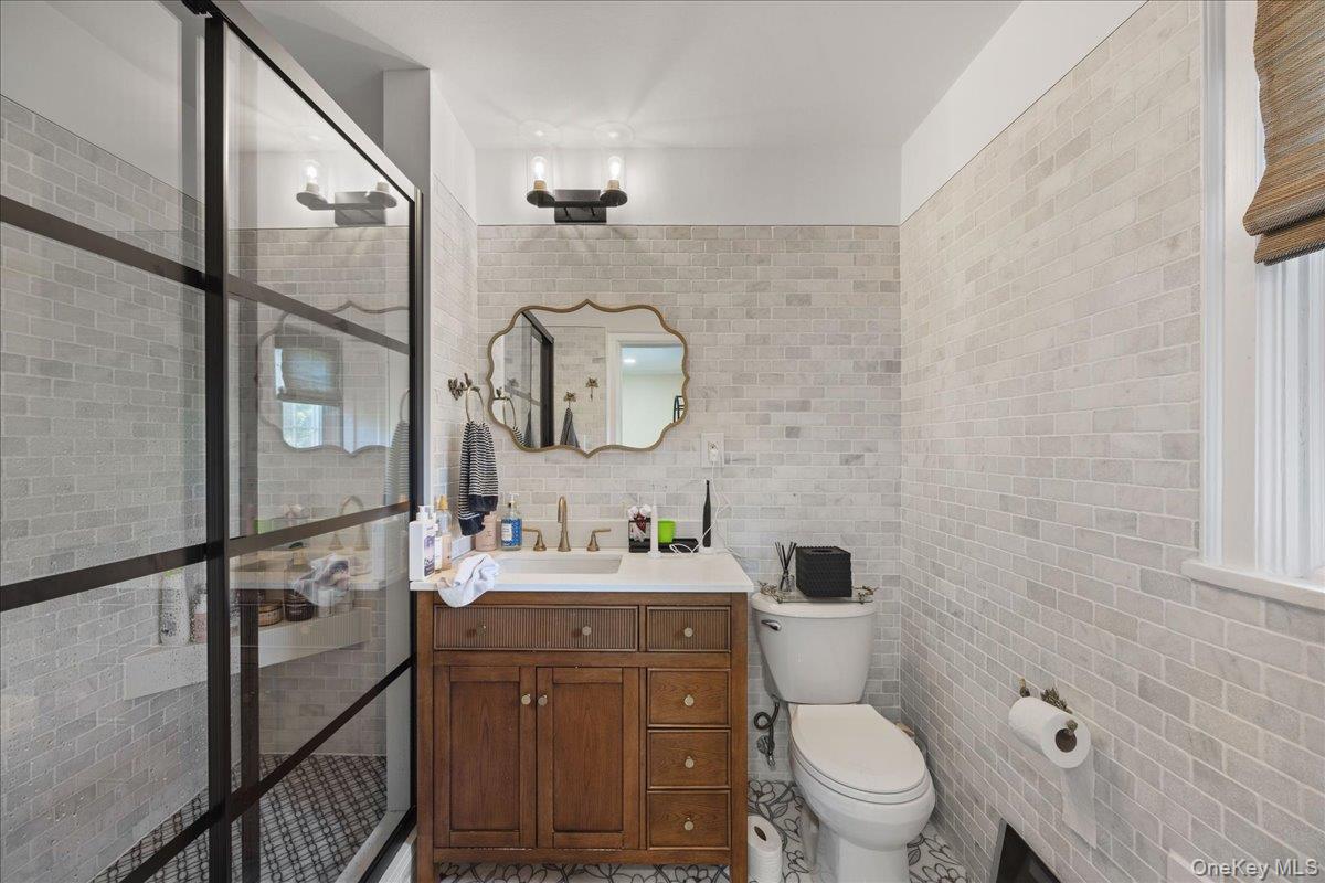 311 Lyncroft Road New Rochelle, NY 10804 - Photo 24 of 39 a bathroom with a toilet a sink and mirror