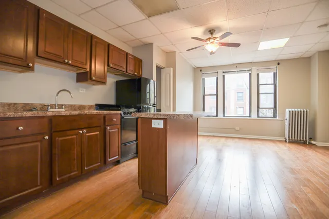 a kitchen with stainless steel appliances granite countertop a sink dishwasher stove and microwave with wooden floor