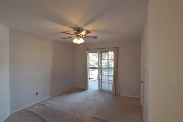 an empty room with chandelier fan