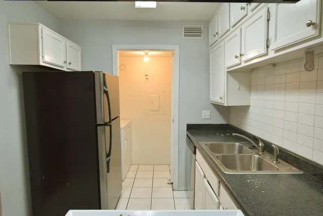 a kitchen with a refrigerator a stove a sink and cabinets