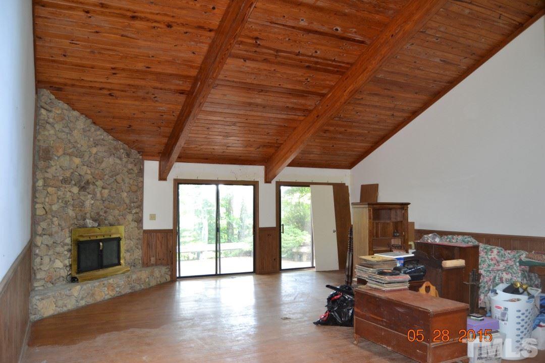 9611 Rougemont Road Bahama, NC 27503 - Photo 13 of 25 a living room with furniture a fireplace and a flat screen tv