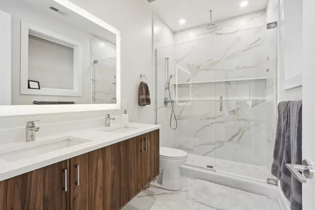 a bathroom with a sink a toilet and shower