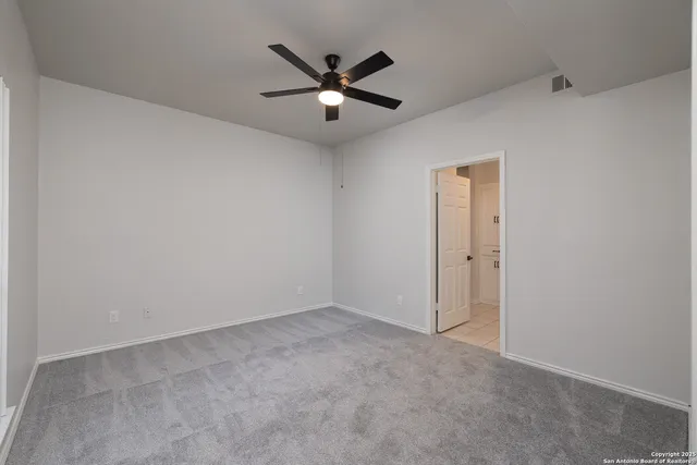 an empty room with closet and ceiling fan