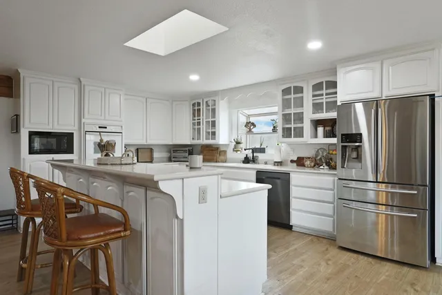 a kitchen with granite countertop stainless steel appliances a refrigerator sink and cabinets