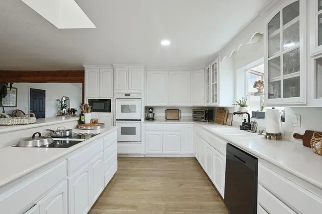 a kitchen with white cabinets and chairs