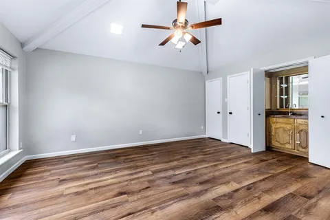 a view of empty room with wooden floor and ceiling fan