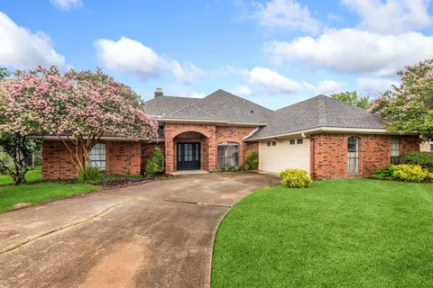 a front view of a house with a garden and trees