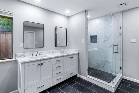 a bathroom with double sink and a mirror
