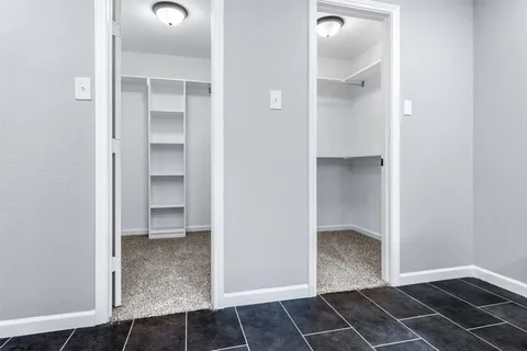 an empty room with wooden floor and cabinet