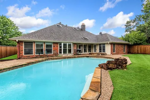 a view of a green field with trees in the background