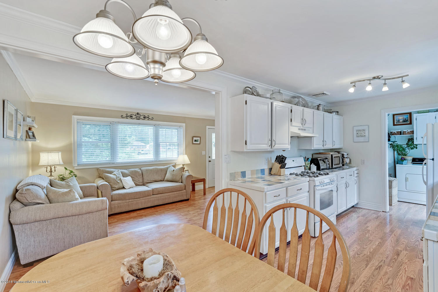 315 Stinson Road Brick, NJ 08723 - Photo 10 of 20 a living room with kitchen island furniture a chandelier wooden floor and a large window