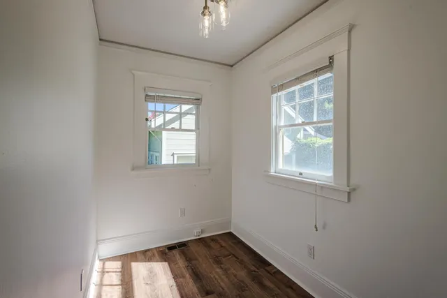 a view of a kitchen with refrigerator and wooden floor