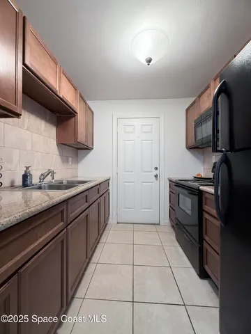a kitchen with granite countertop stainless steel appliances a sink stove top oven and cabinets