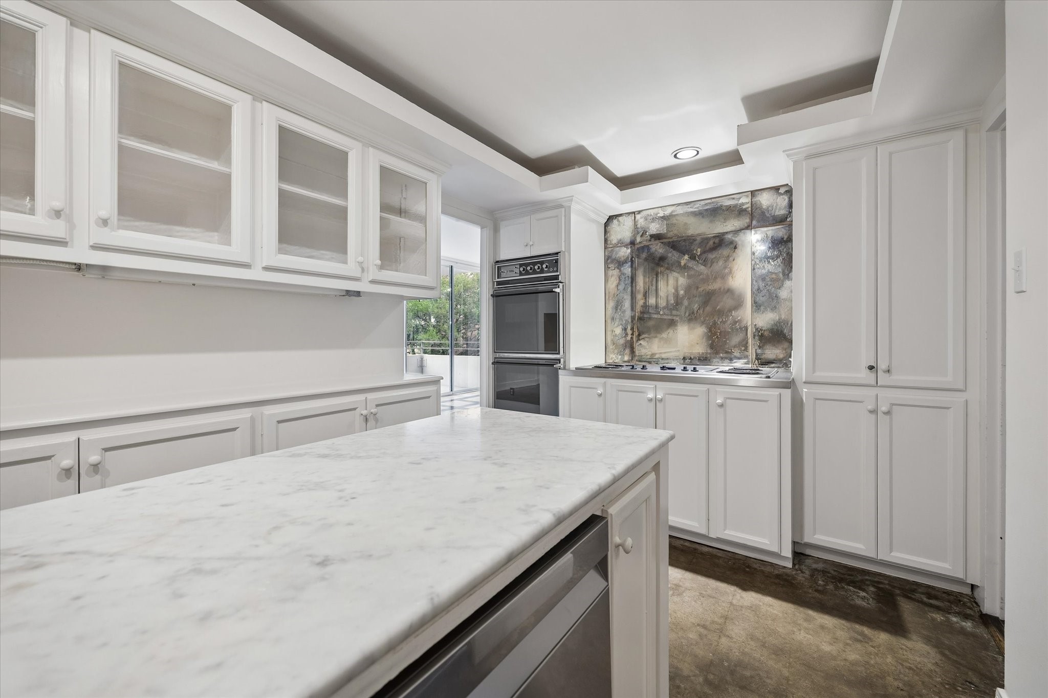2701 Westheimer Road, Unit 2B Houston, TX 77098 - Photo 8 of 16 Kitchen with glass front cabinetry, electric cooktop and double ovens.