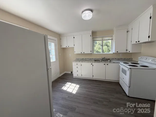 a view of a kitchen with wooden floor and a window