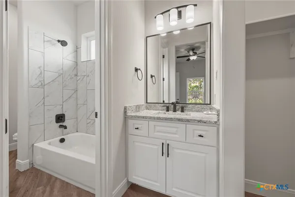 a bathroom with a bathtub a sink and a mirror