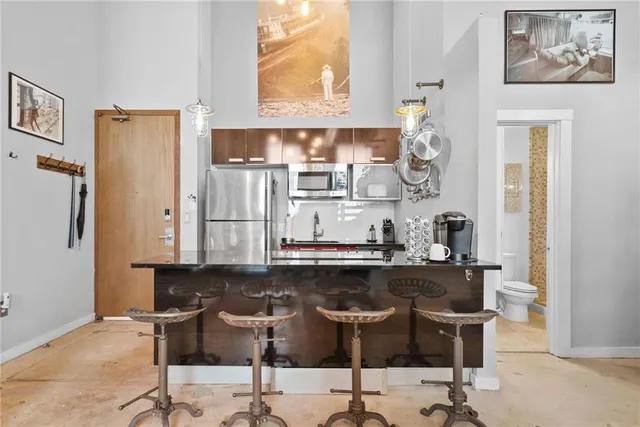 a kitchen with stainless steel appliances kitchen island granite countertop a refrigerator and a stove top oven