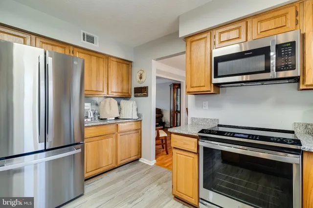 a kitchen with stainless steel appliances a stove microwave and sink