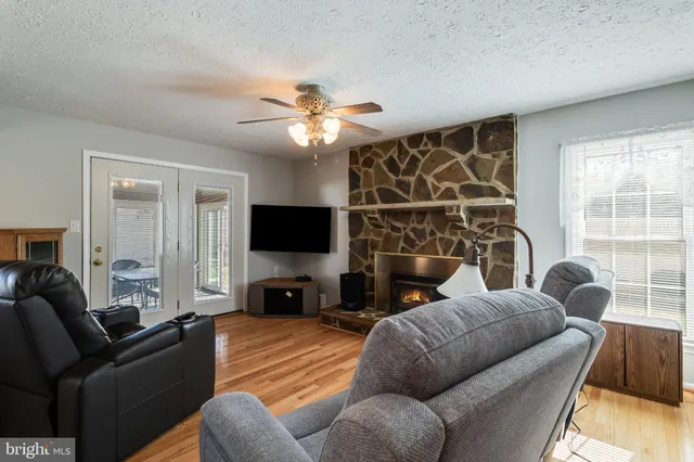 a living room with furniture a flat screen tv and a large window