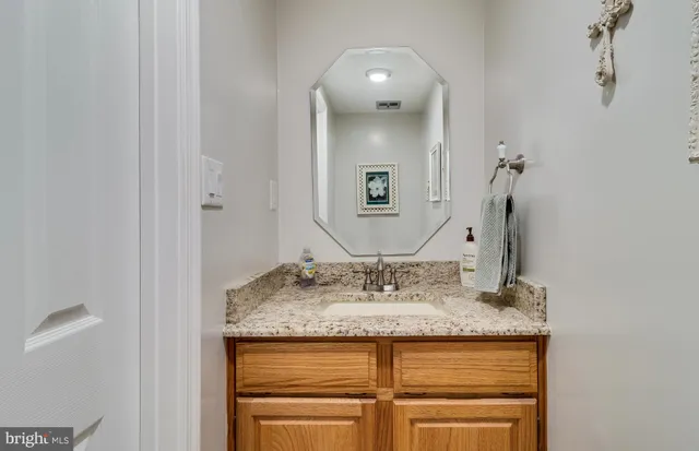 a bathroom with a granite countertop sink and a mirror