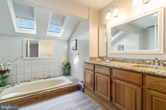 a bathroom with a tub a sink and mirror
