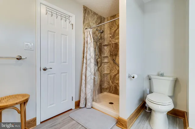 a bathroom with a shower a toilet and a shower