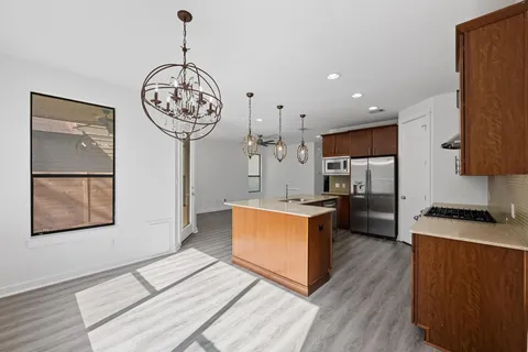 a kitchen with stainless steel appliances granite countertop a stove a refrigerator a sink a oven with wooden floor and cabinets