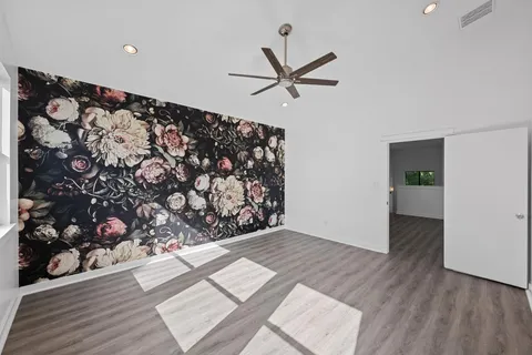 a view of a big room with wooden floor and entryway