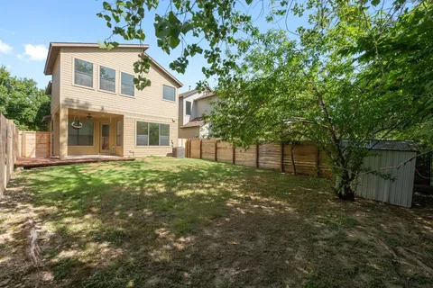 a view of a yard in front of a house with large trees