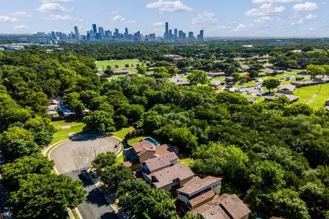 an aerial view of residential houses with outdoor space and swimming pool