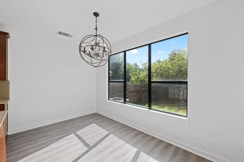 a view of a hallway with wooden floor and a window