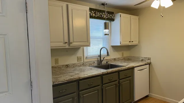 a kitchen with granite countertop a sink and cabinets