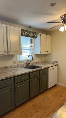 a kitchen with granite countertop a sink and cabinets