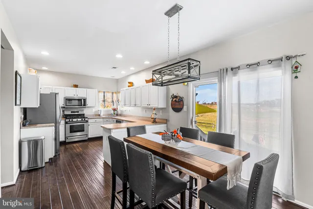 a view of a dining room and livingroom with furniture wooden floor a chandelier