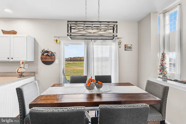 a kitchen with stainless steel appliances granite countertop a dining table chairs and chandelier